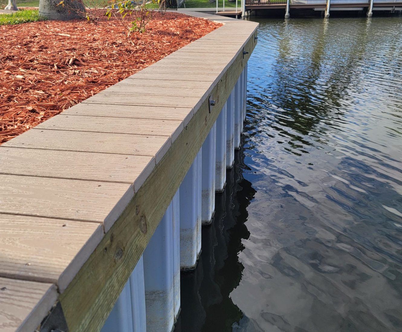 Marine contractor applying pressure grout to reinforce aging seawall in Stuart, FL.